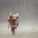 Klara-Marie Schulze mit selbsthergestellter Ausrüstung wandert durch eine Wiese mit Morgentau